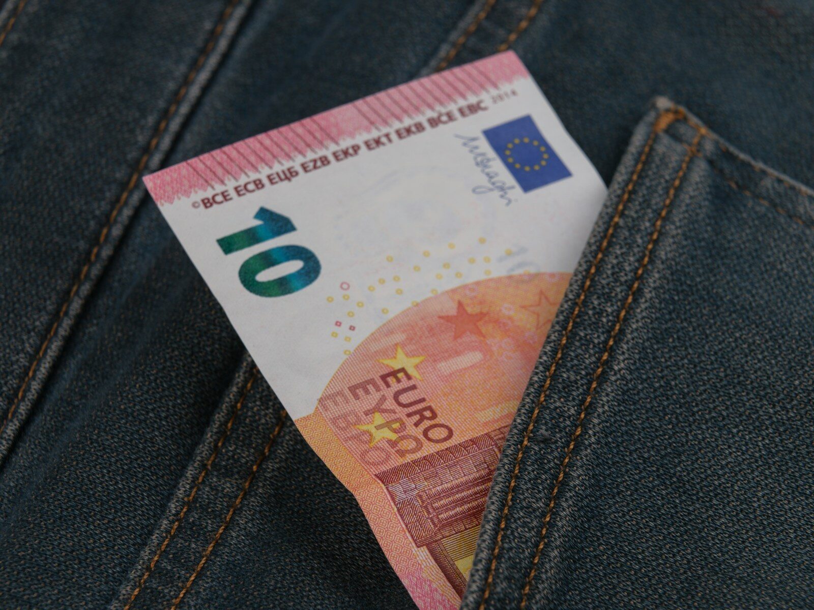a money bill sticking out of the back pocket of a pair of jeans