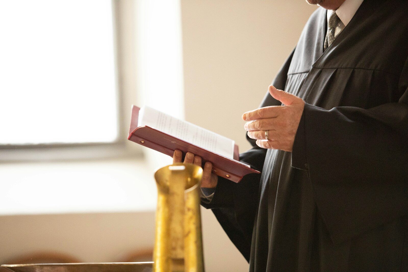 a man in a black robe holding a book